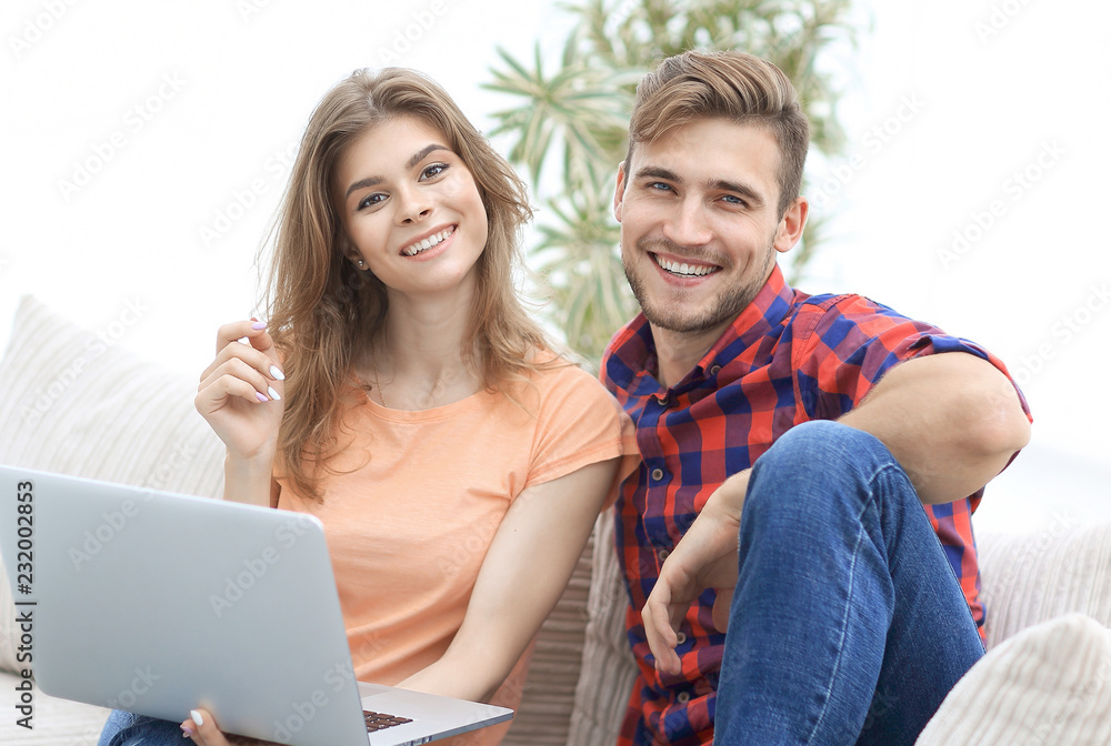 Poster young couple of students with laptop sitting on the couch