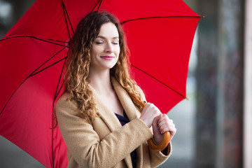 Portrait of a young ginger woman with umbrella outdoors