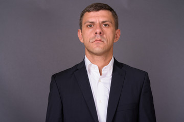 Handsome businessman with short hair against gray background