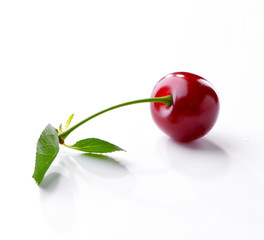 Cherry berry with leaf on twig close-up  lying on white background
