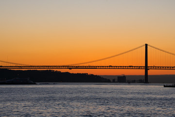 Sunset view of Tagus river (Rio Tajo) and 25th of April Bridge (Ponte 25 de Abril). Lisbon, Portugal