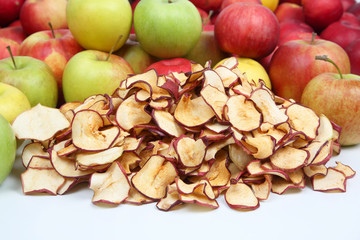 Naklejka na ściany i meble Dried slices of apples on a background of fresh apples