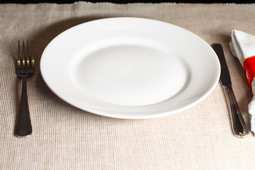 empty plate with fork and knife on wooden background
