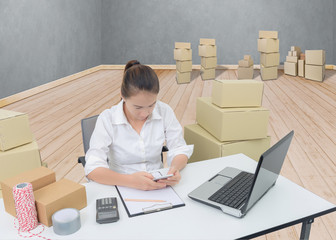 teenager owner business woman work at home with smartphone, laptop for online shopping writing the order.