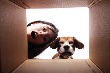 Teen girl and her dog looking at something inside a box