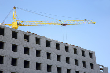 Construction crane on the construction of a brick house