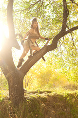 Girl in the Amazon suit posing on nature on a sunny evening. Cosplay. Toned photo.

