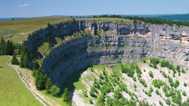 Cinematic aerial shot gliding over the edge of the Creux du Van