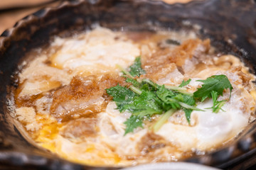 Close up of nabe miso soup with onsen egg and tonkutsu.