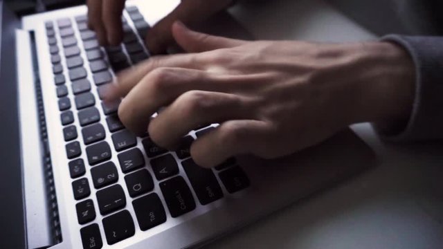 Man typing on laptop keyboard