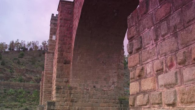 Cinematic tracking shot of Alc&radic;&deg;ntara Bridge at sunset