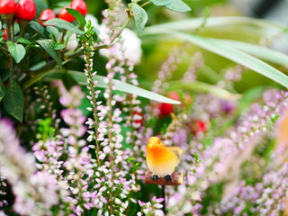 木製の小鳥と季節の花々