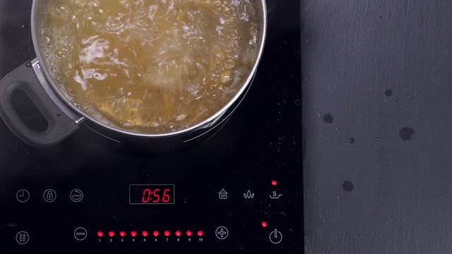 Boiling pasta in pan, throw macaroni into pot