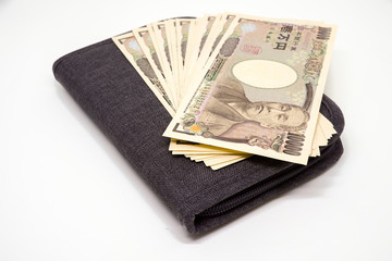 Japanese 10,000 Yens Banknote on Passport Holder on White Background