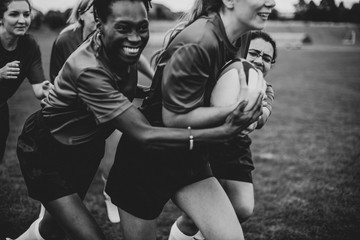 Energetic female rugby players on the field - obrazy, fototapety, plakaty