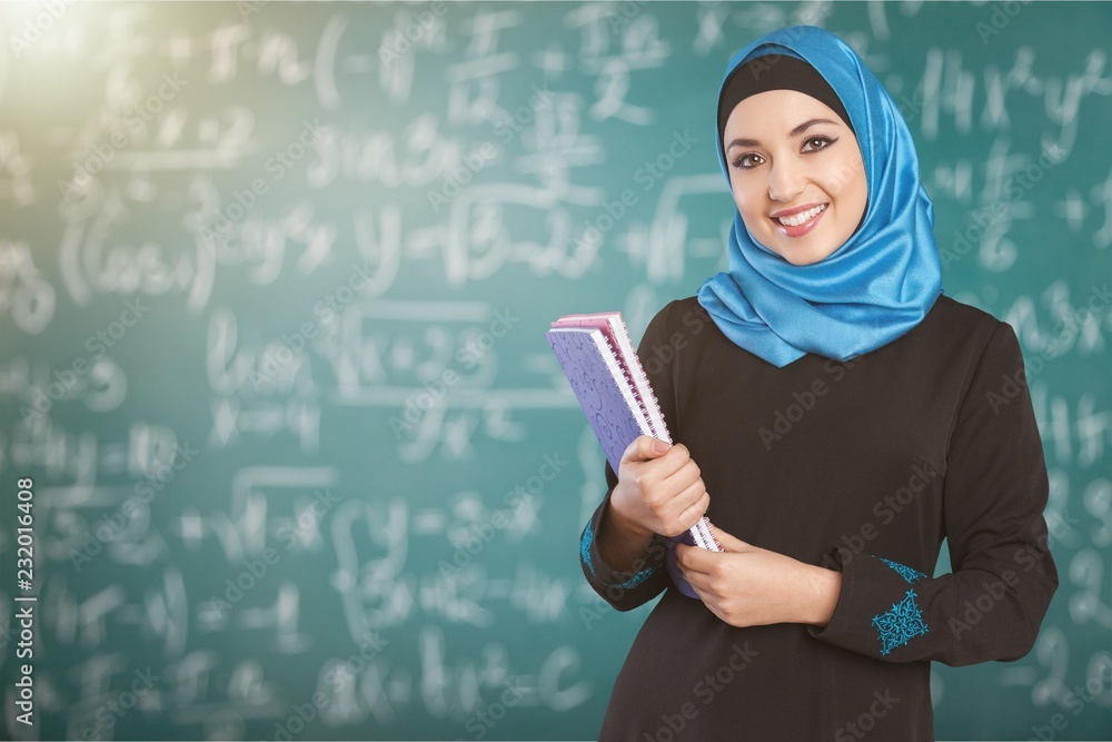 Wall mural Beautiful Young Muslim Woman with notebooks on  background