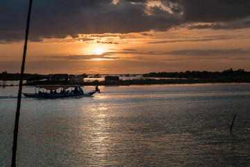 Fototapeta na wymiar magical sunset on the lake with backlight boat
