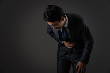 お腹を押さえるビジネスマン