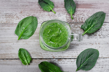 Detox concept. Spinach smoothie in mason jar. Healthy Raw Vegetarian Smoothie on wooden table. Top view, flat lay
