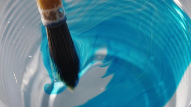 Abstract background. Blue ink in a glass of water. Liquid watercolors.