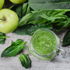 Detox concept. Spinach smoothie in mason jar. Healthy Raw Vegetarian Smoothie on wooden table. Top view, square image