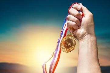 Plakat Gold medal with ribbon in hand on background