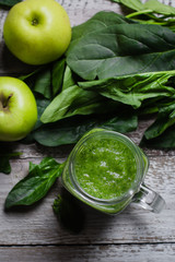 Detox concept. Spinach smoothie in mason jar. Healthy Raw Vegetarian Smoothie on wooden table. Top view, flat lay