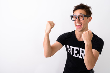 Studio shot of young happy nerd man smiling while thinking and l