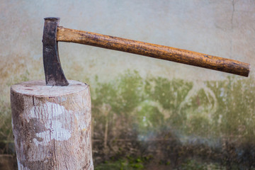 Old axe on a tree stump for chopping firewood.