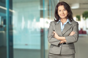 Mature businesswoman wearing formal suit on background
