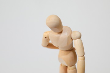 Wooden doll posing back pain