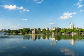 Fototapeta na wymiar Hoan Kiem lake or Sword lake, Ho Guom in Hanoi, Vietnam with Turtle Tower, on clear day with blue sky and white clouds