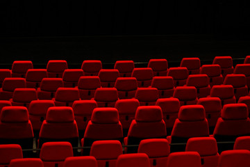 A theater in which red chairs line up in rows