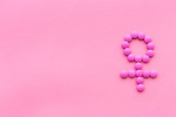 Female diseases. Female gender icon symbol made of pills on pink background top view copy space