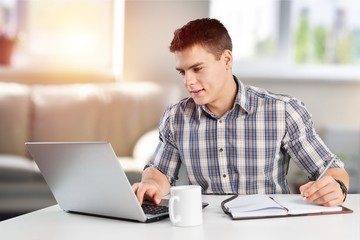 Concentrated young man usind laptop