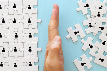 image of puzzle with people icons over wooden table ,human resources and management concept.