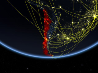 Chile on model of planet Earth at night with network representing travel and communication.