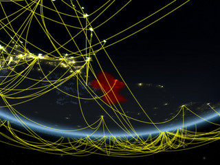 Guyana on model of planet Earth at night with network representing travel and communication.