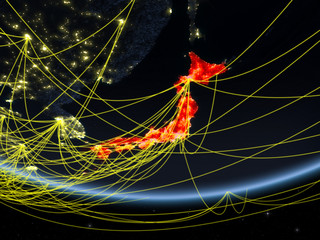 Japan on model of planet Earth at night with network representing travel and communication.