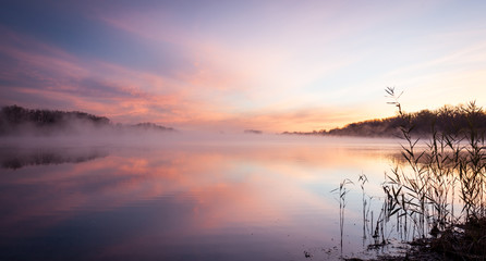 Fototapeta na wymiar lake at sunrise in pink fog and clouds