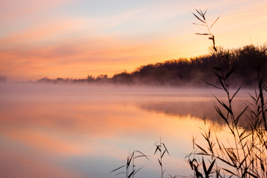 lake at sunrise in pink fog and clouds
