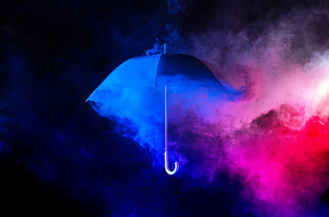 Abstract concept - blue umbrella among colorful dust clouds