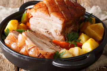 German pork krustenbraten baked in beer with vegetables and gravy close-up in a frying pan. horizontal