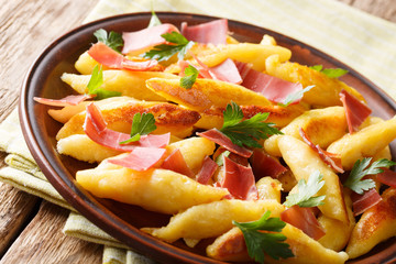 German potato schupfnudeln with ham and herbs close-up on a plate. horizontal