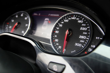 old speedometer on the dashboard of the black car