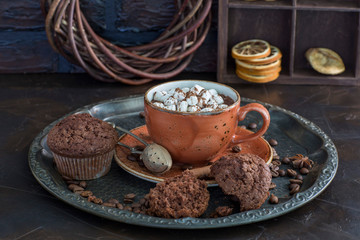 Hot chocolate with marshmallows and muffins on the table