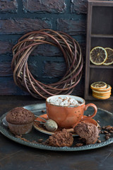 Hot chocolate with marshmallows and muffins on the table