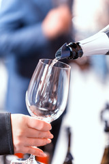 White wine is poured into a glass. Festive party