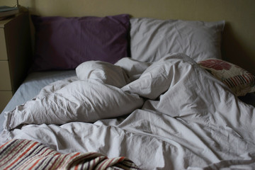 Fototapeta na wymiar Crumpled bedding on the bed