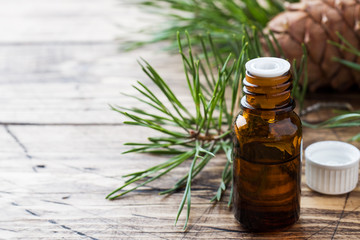 Cedar and spruce essential oil in small glass bottles on wooden background. Selective focus.